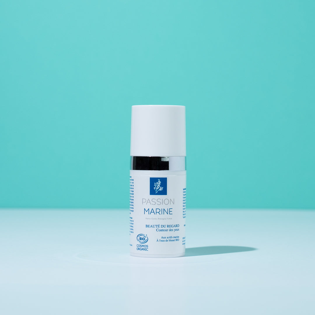 Flacon de crème contour des yeux Passion Marine sur fond turquoise.