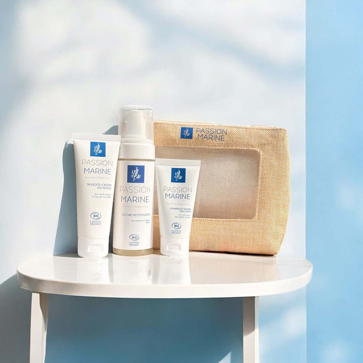 Produits Passion Marine sur une table blanche avec trousse beige en arrière-plan.