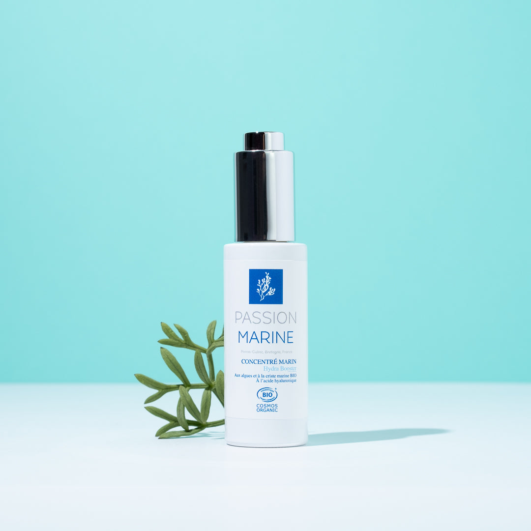 Flacon de soin "Passion Marine" sur fond bleu avec branche verte.
