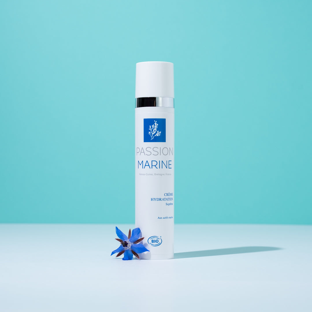 Crème hydratante Passion Marine avec fleur bleue sur fond turquoise.