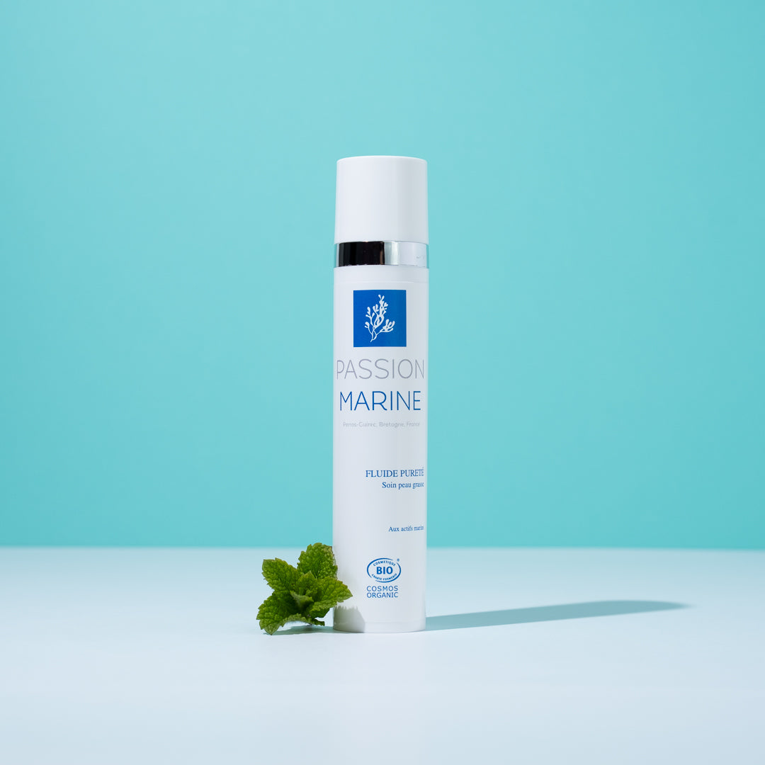 Flacon "Passion Marine" sur fond bleu avec feuille verte.