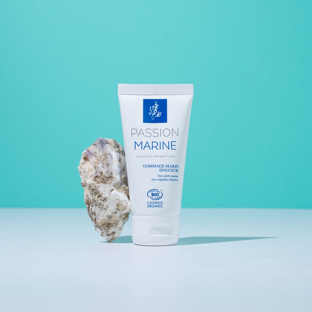 Tube de gommage marin Passion Marine avec une roche, fond turquoise.